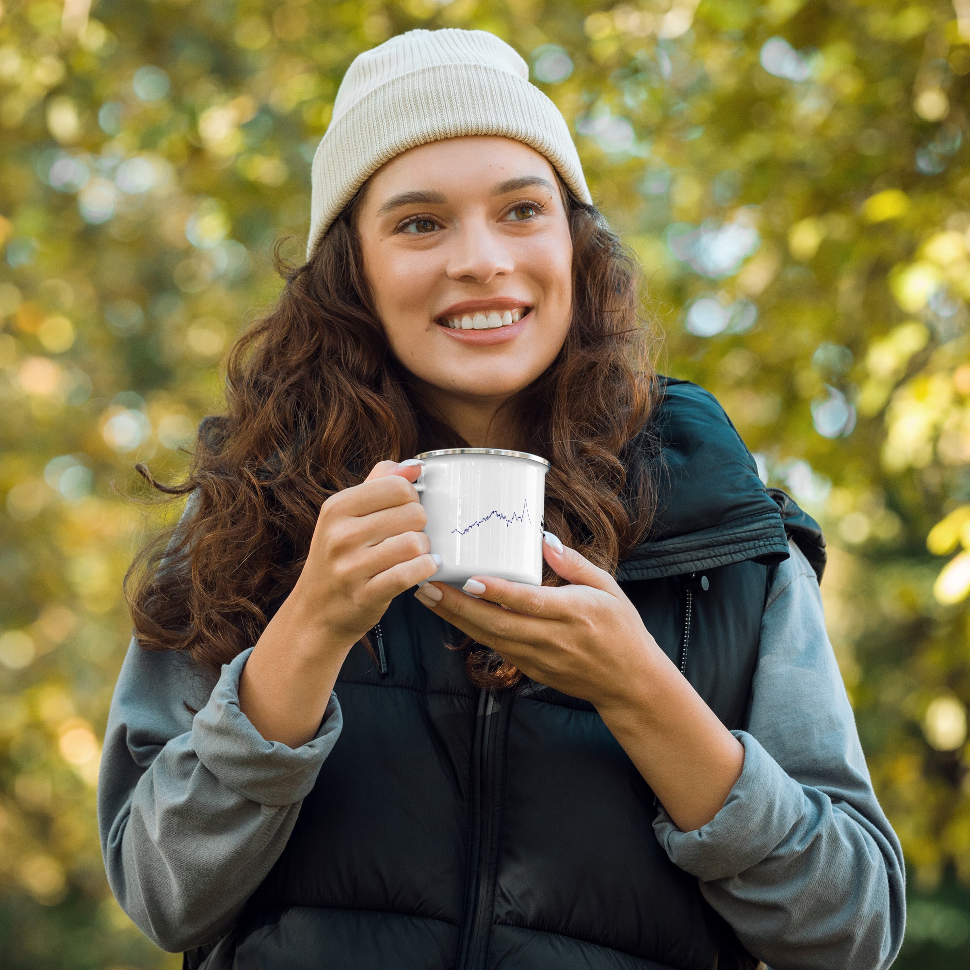 Woman holding a mug with custom Strava route print outdoors with trees in the background