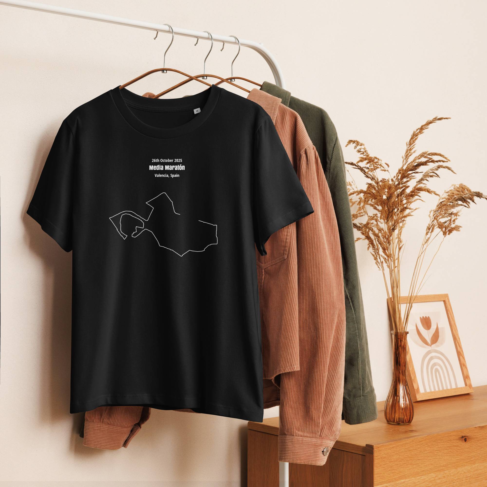 Black t-shirt with a white custom Strava route print on a hanger against a neutral background
