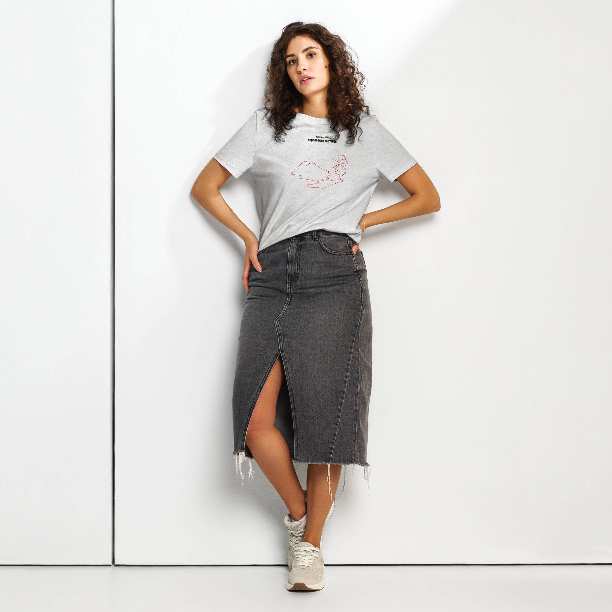 Woman wearing a white t-shirt with custom Strava route print and denim skirt on a white background