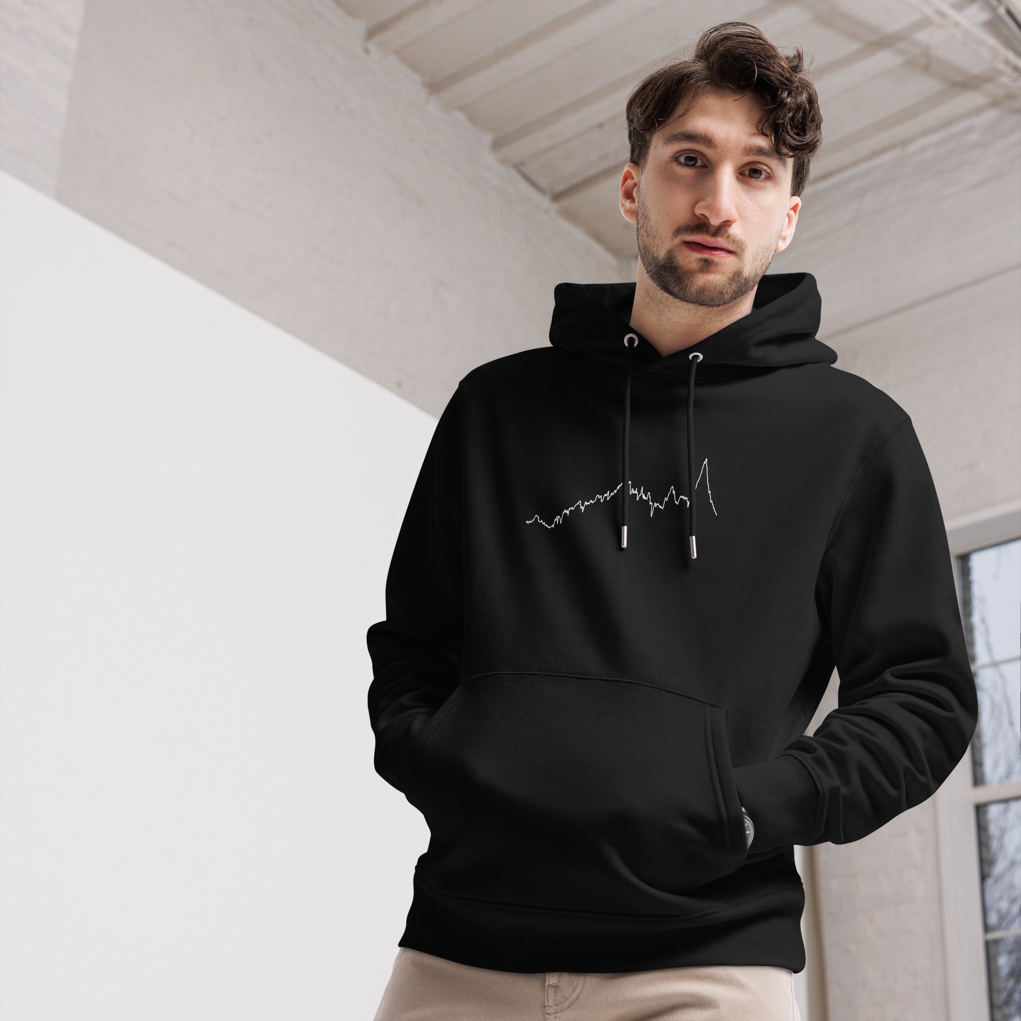Man wearing a black hoodie with a custom Strava route print art design indoors