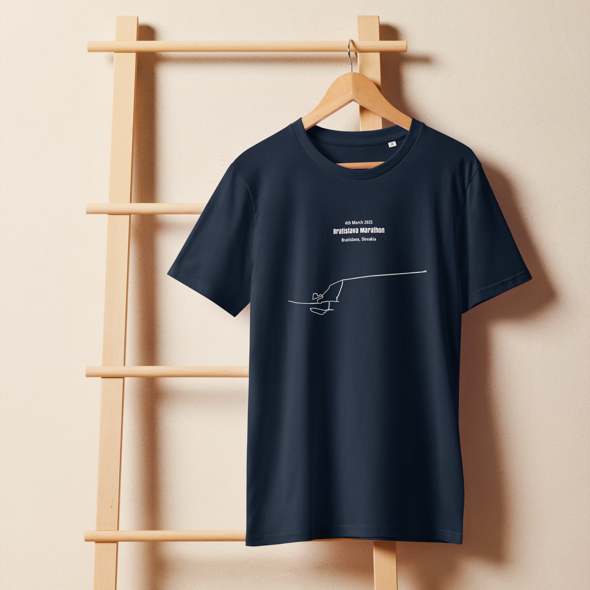 Navy blue t-shirt with a white custom Strava route print art on a wooden hanger against a beige wall