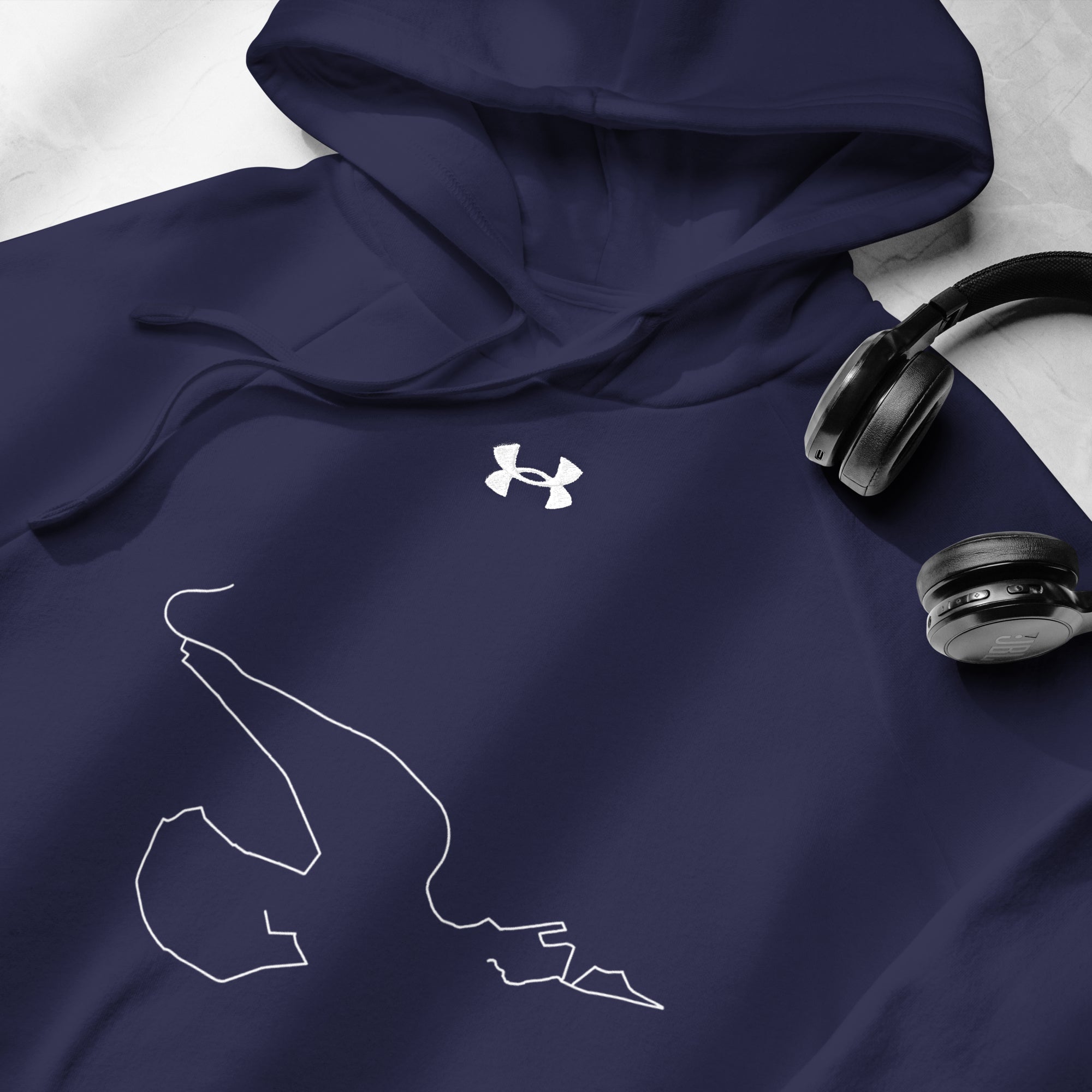 Navy hoodie with white logo and custom Strava route print design, paired with black headphones on a light gray background