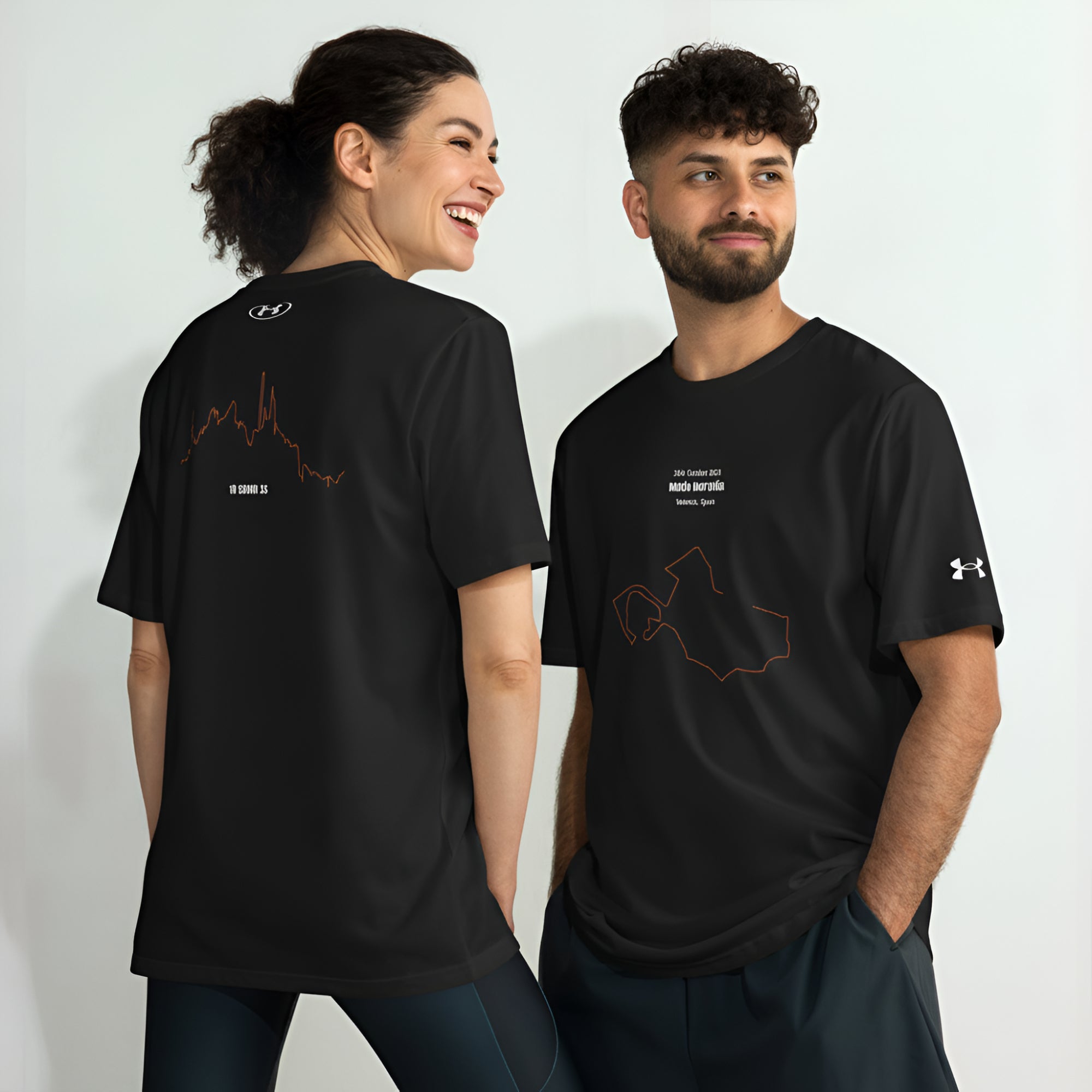 Two people wearing black Under Armour t-shirts with custom Strava route and elevation print designs on a white background