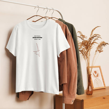 White t-shirt with text and custom Strava route print on a hanger against a neutral wall with clothes and decor