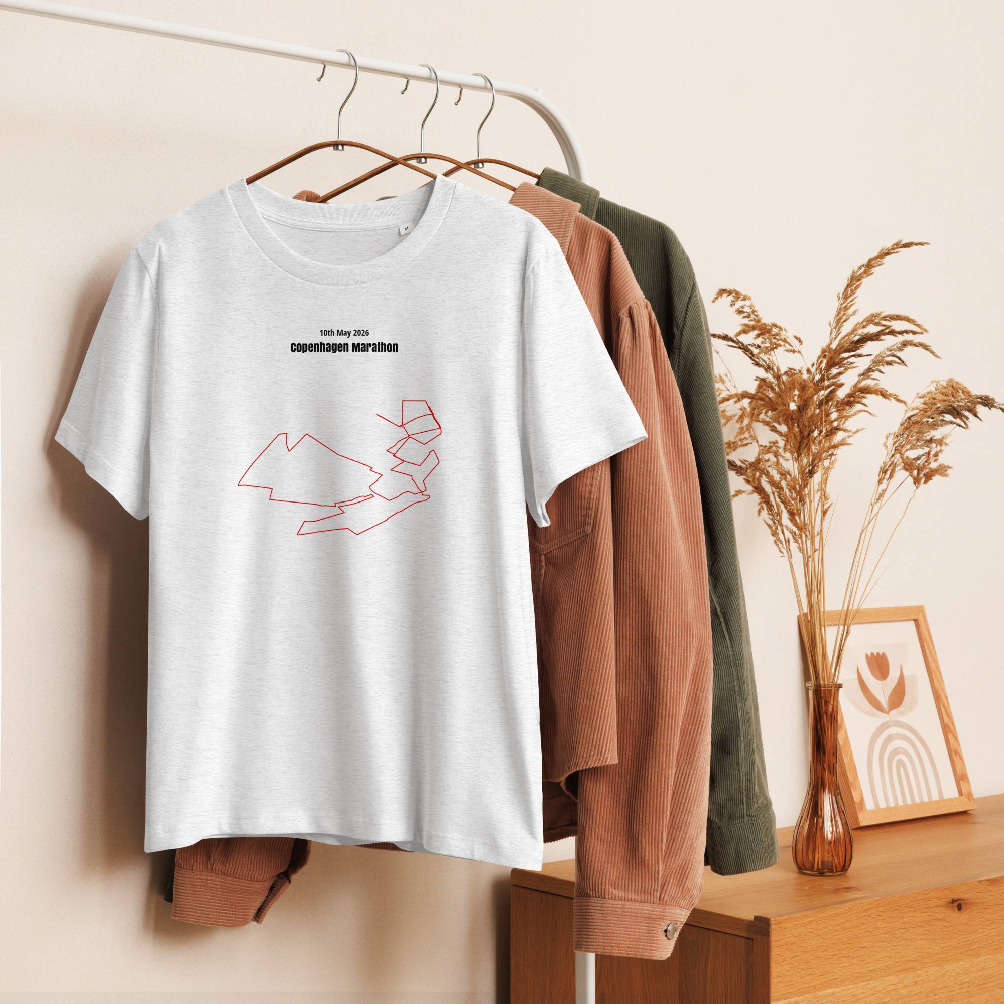 White t-shirt with a custom Strava route print design on a hanger against a neutral background