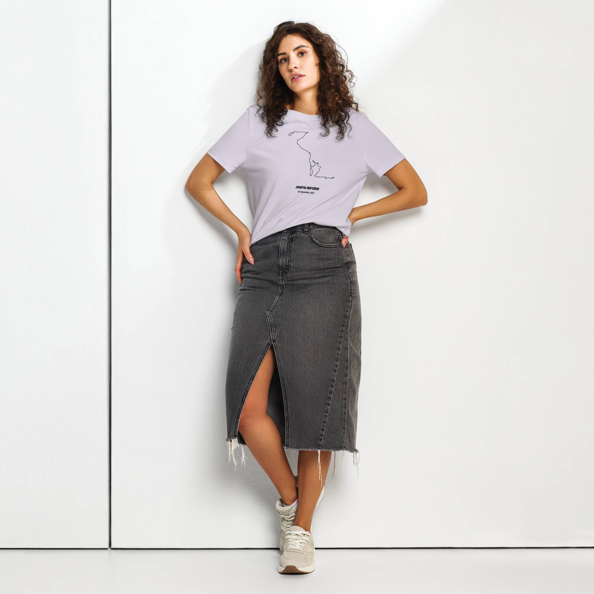 Woman wearing a light purple t-shirt with custom Strava route print and dark denim skirt on a white background