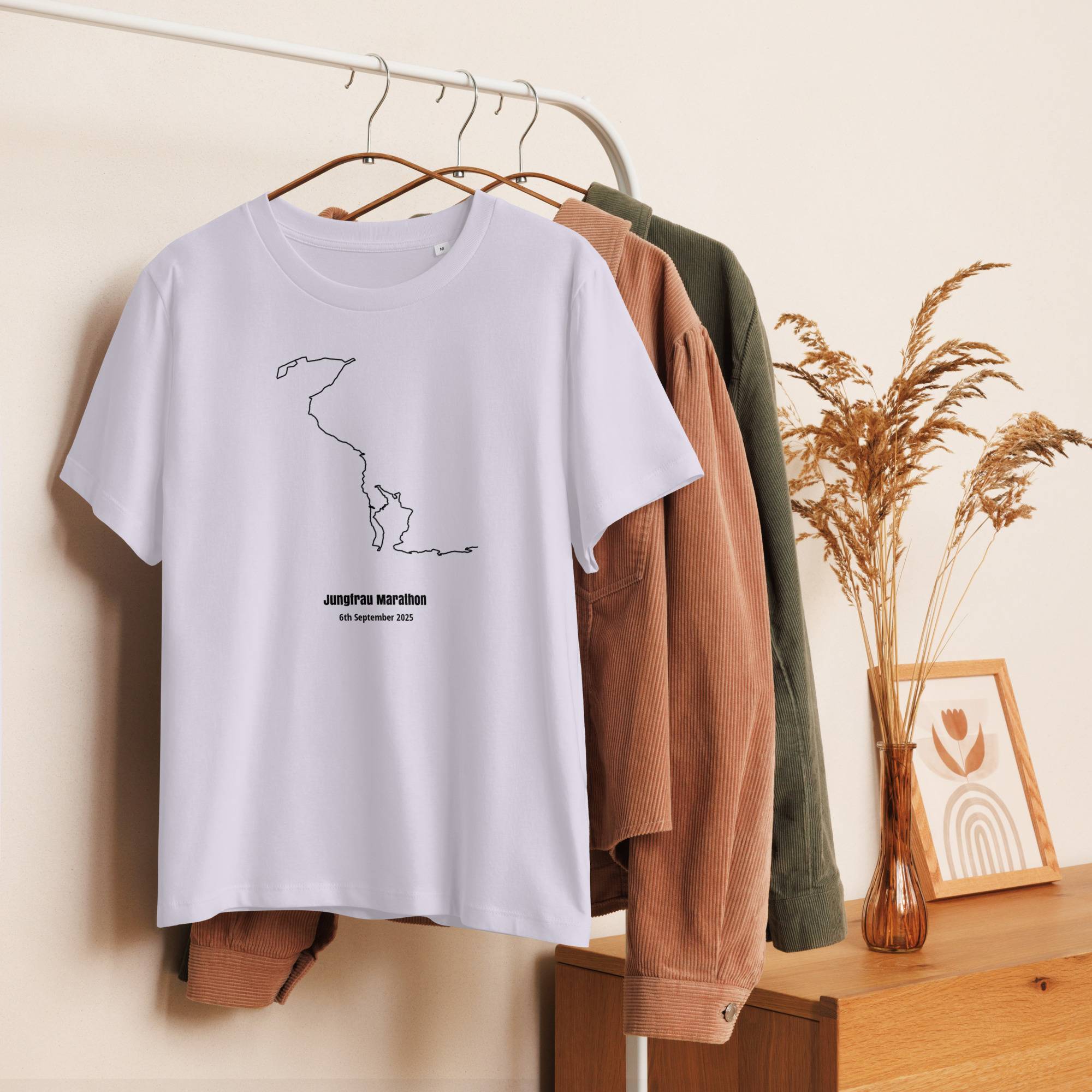 White t-shirt with a custom Strava route print design hanging on a rack with other clothes