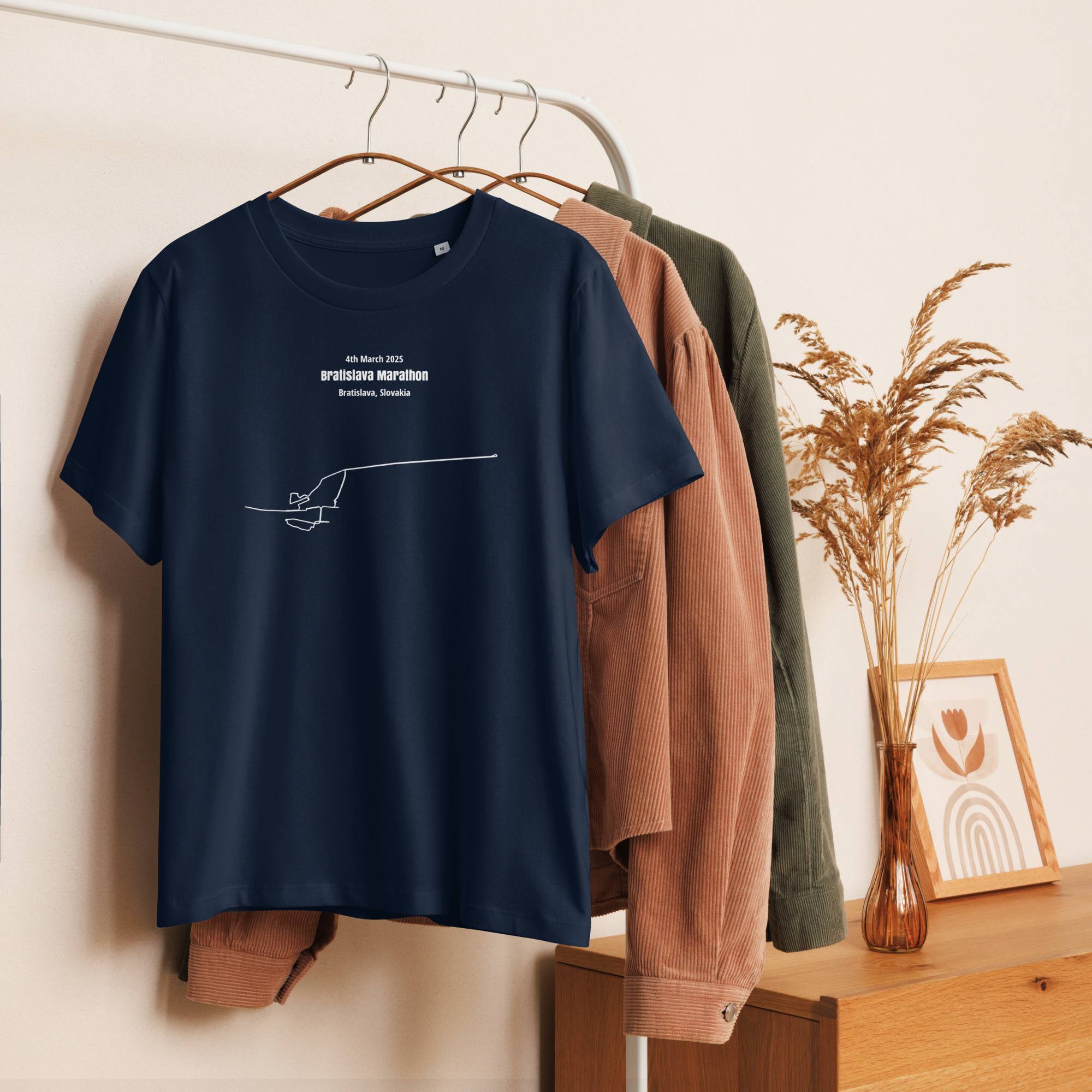 Navy blue t-shirt with white text and custom Strava route print design on a hanger against a neutral background