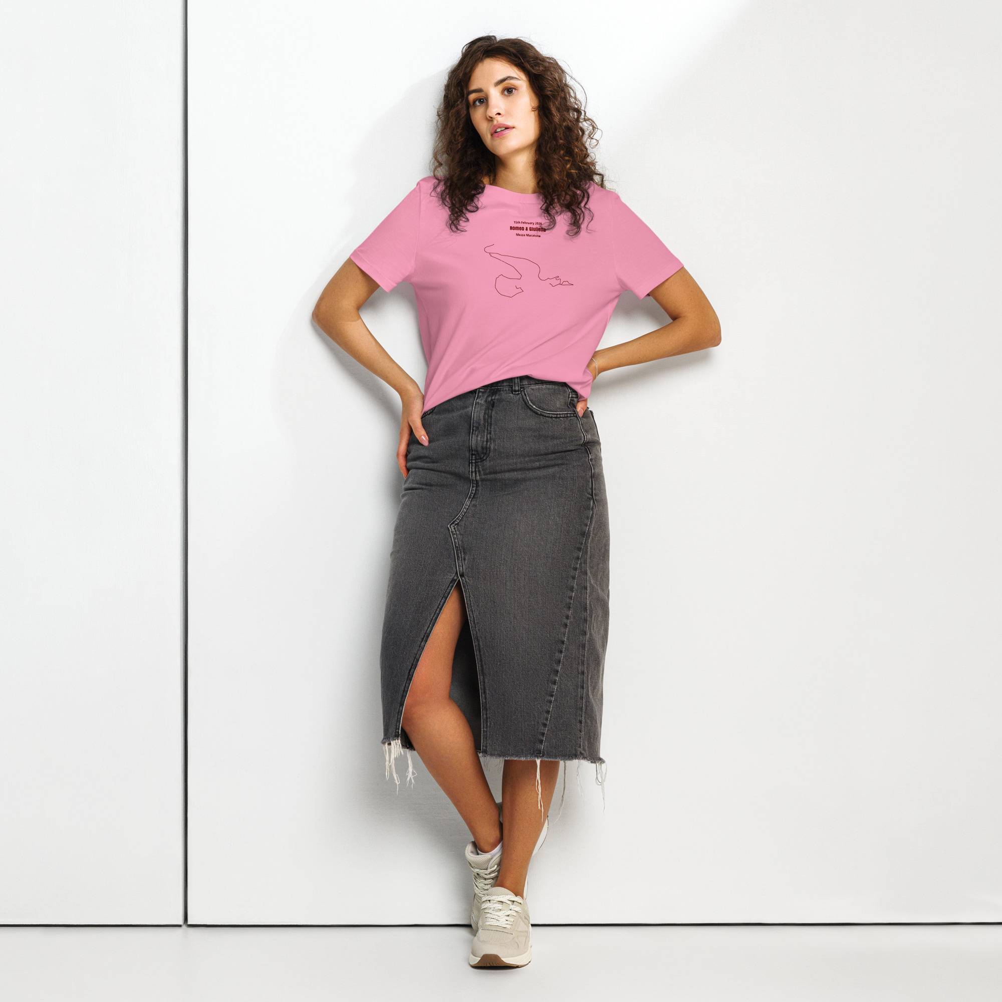Woman wearing a pink t-shirt with custom Strava route print and black denim skirt on a white background