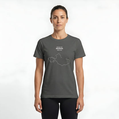 Woman wearing a gray t-shirt with custom Strava route print art design and black shorts on a white background