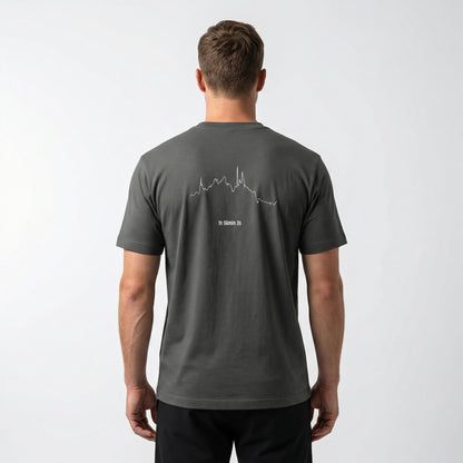 Man wearing a dark gray t-shirt with a white custom Strava route print art design on the back against a white background