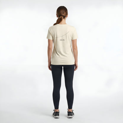 Woman wearing a beige t-shirt with custom Strava route print art design on the back against a white background