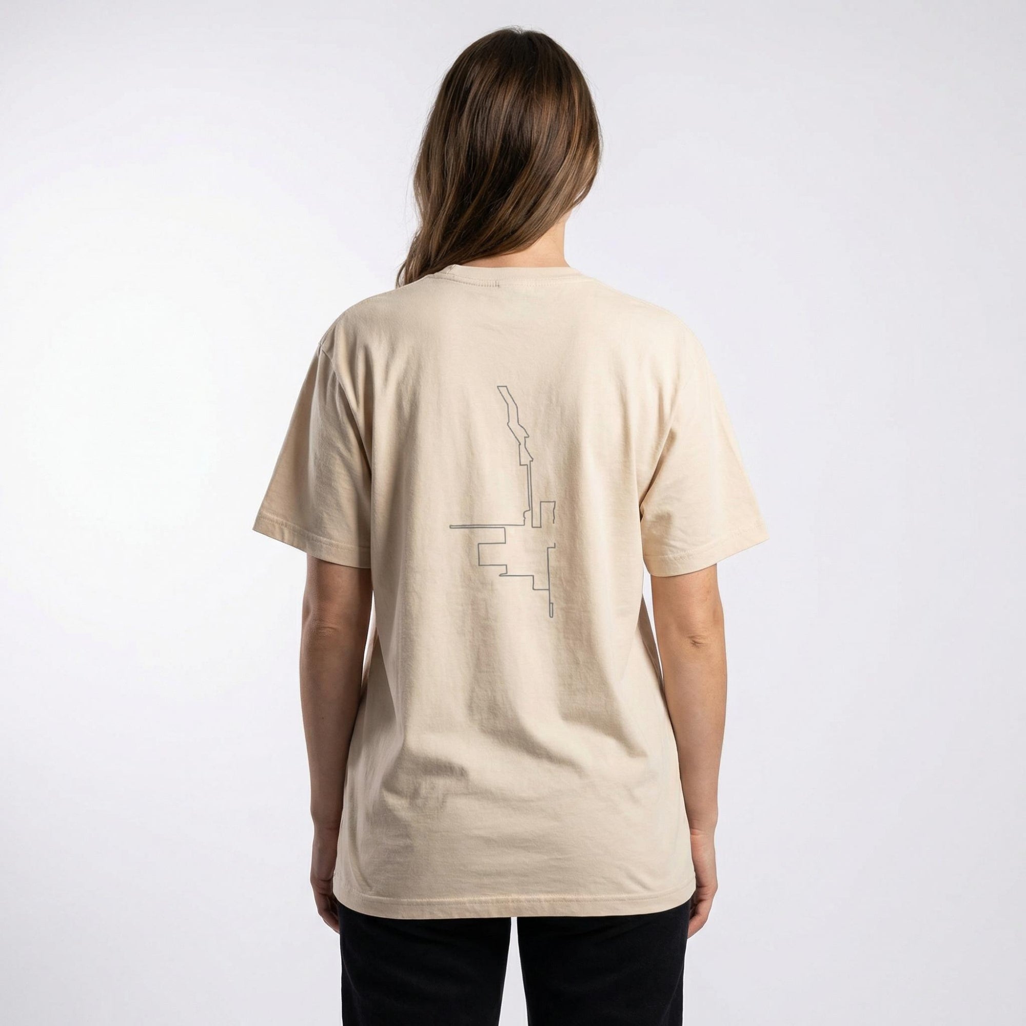 Person wearing a beige t-shirt with a custom Strava route print art design on the back against a white background