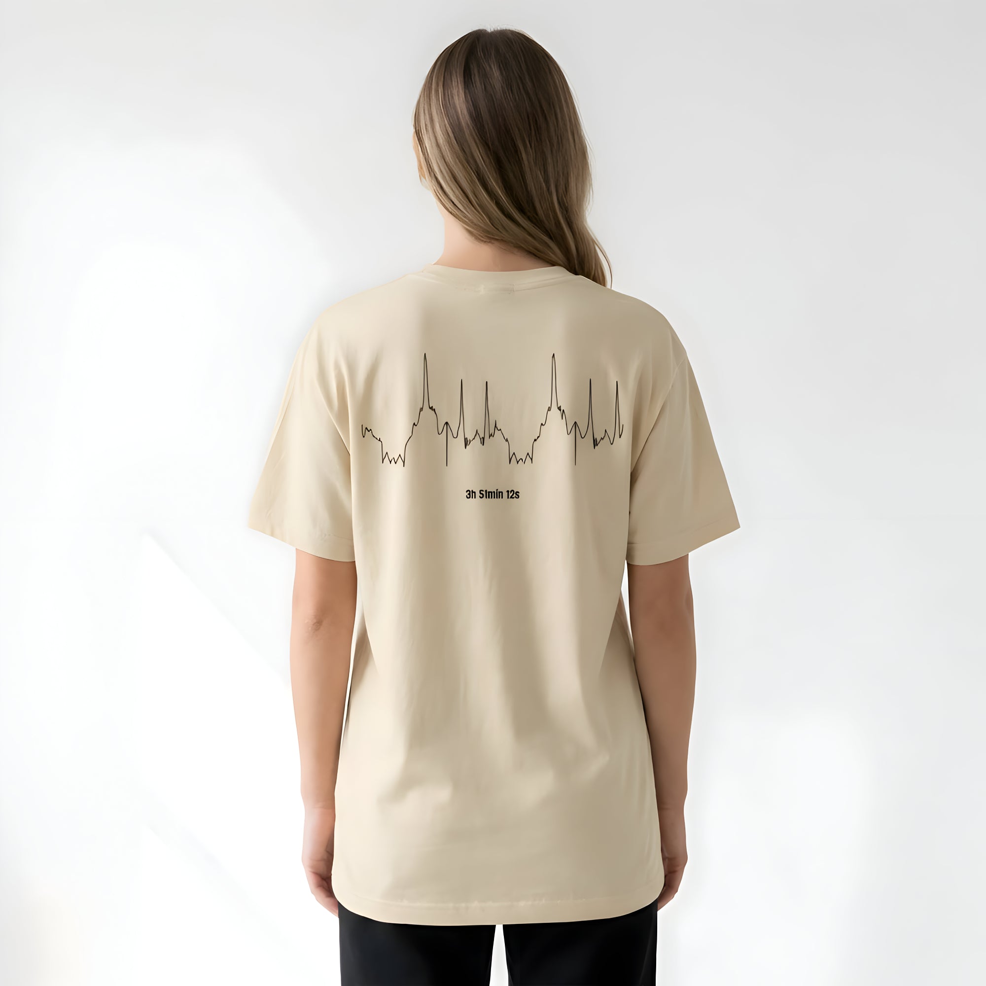 Person wearing a beige t-shirt with a custom Strava route print art design on the back against a white background