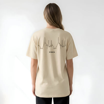 Person wearing a beige t-shirt with a custom Strava route print art design on the back against a white background