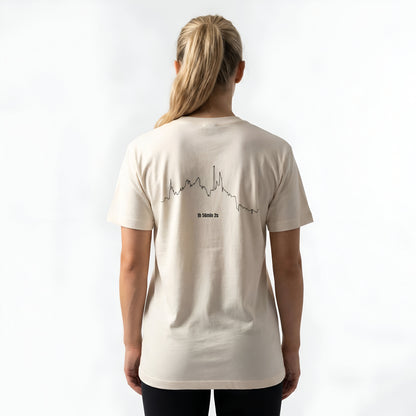 Person wearing a beige t-shirt with custom Strava route print art design on the back against a white background