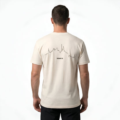 Man wearing a beige t-shirt with custom Strava route print art design on the back against a white background