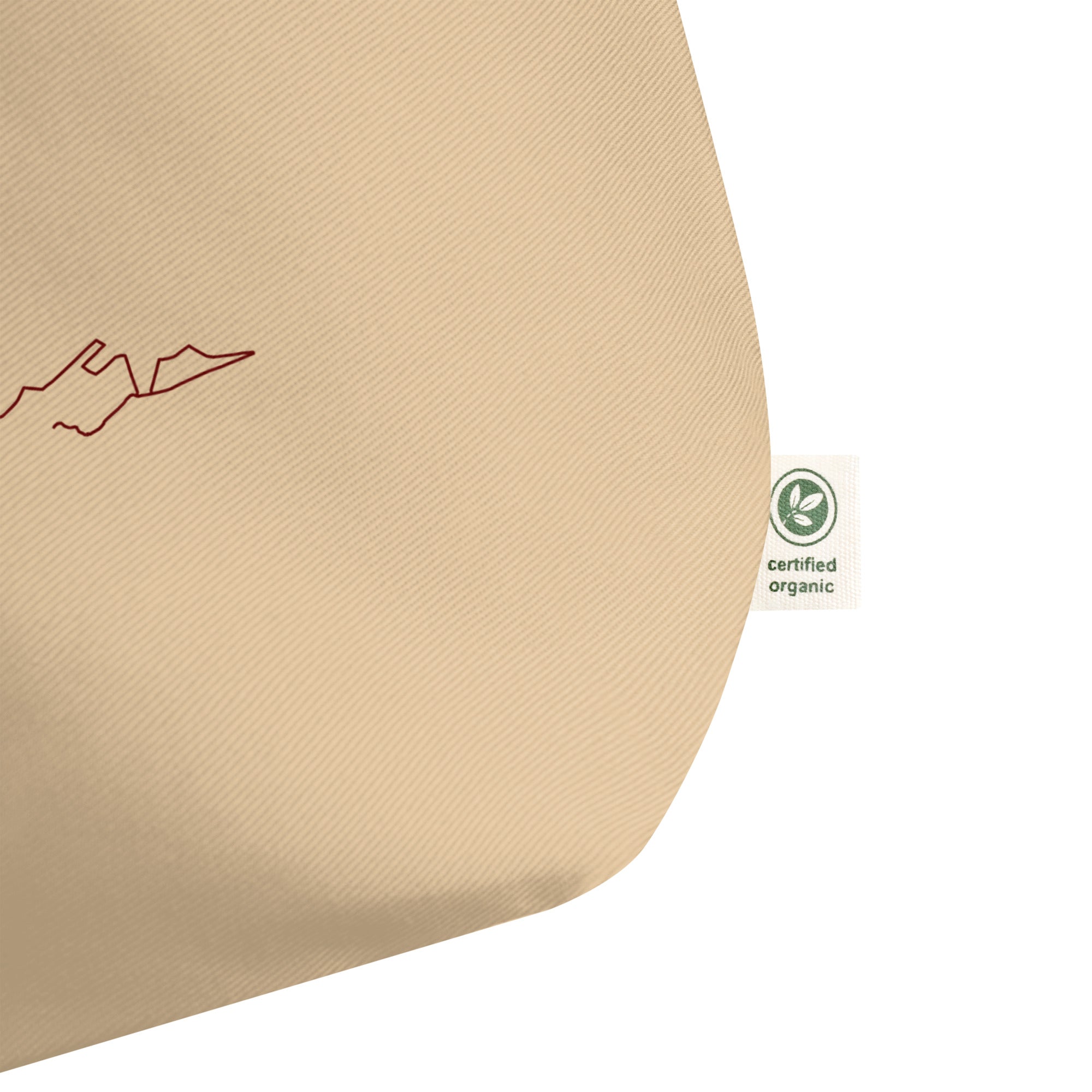 Beige fabric with red custom Strava route print art outline and green organic certification label on a white background