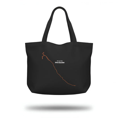 Black tote bag with a custom Strava route print art design and text on a white background