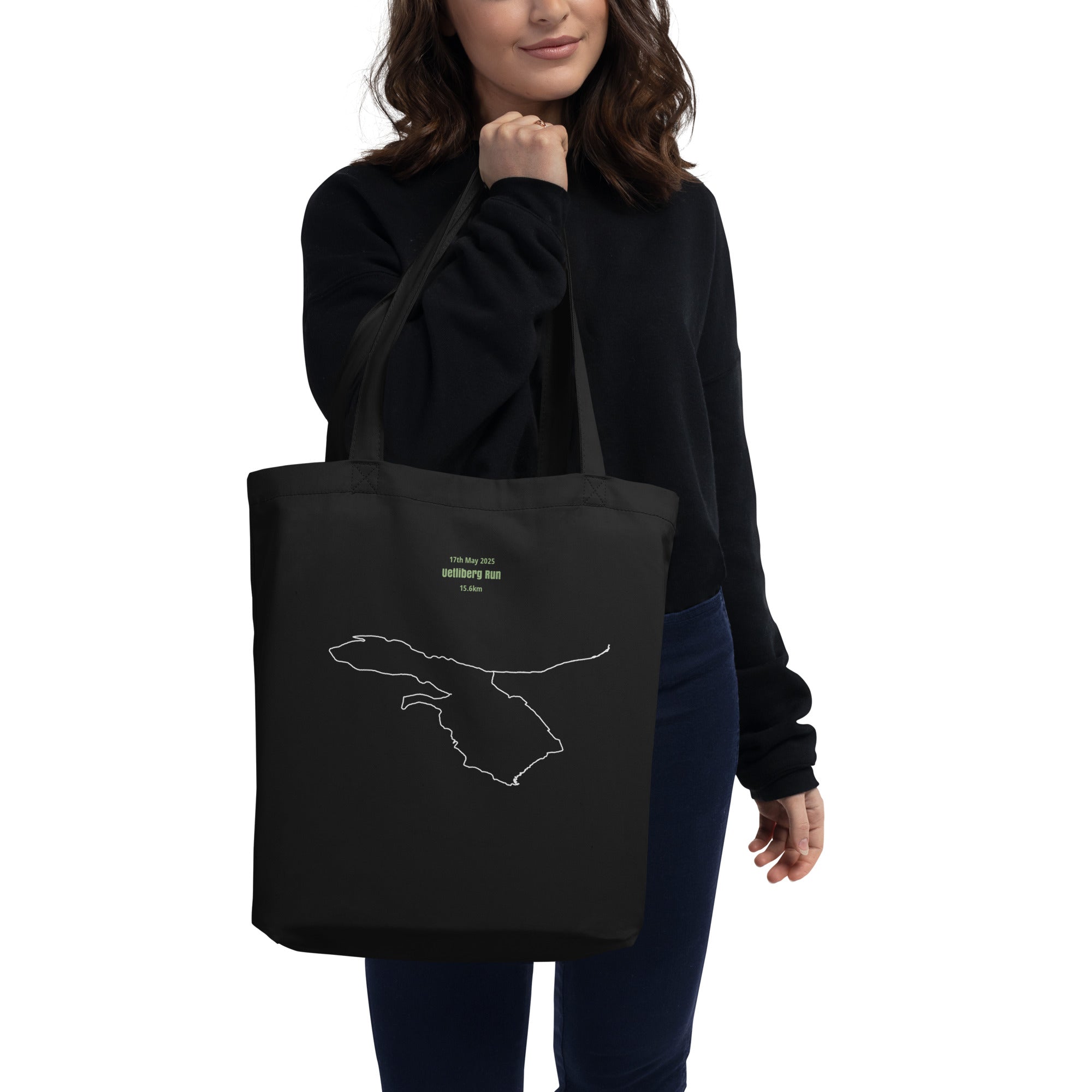 Person holding a black tote bag with a white custom Strava route print art design on a white background
