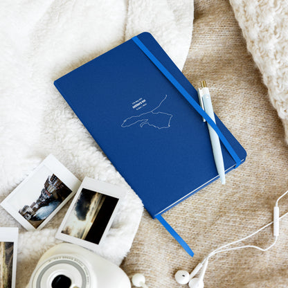 Blue notebook with custom Strava route print art and photos on a textured surface