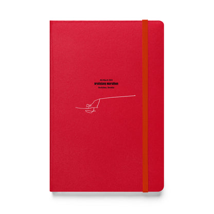 Red notebook with a white custom Strava route print art on a white background