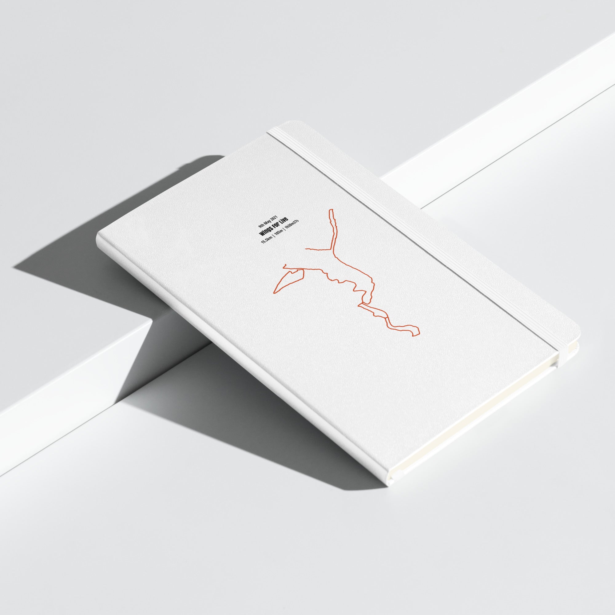 White card with a red custom Strava route print art on a gray surface