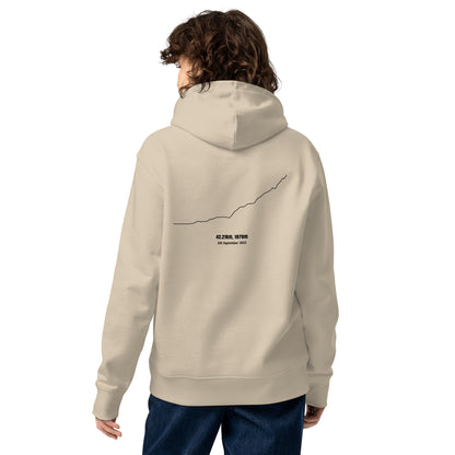 Person wearing a beige hoodie with a custom Strava route print art design on the back against a white background