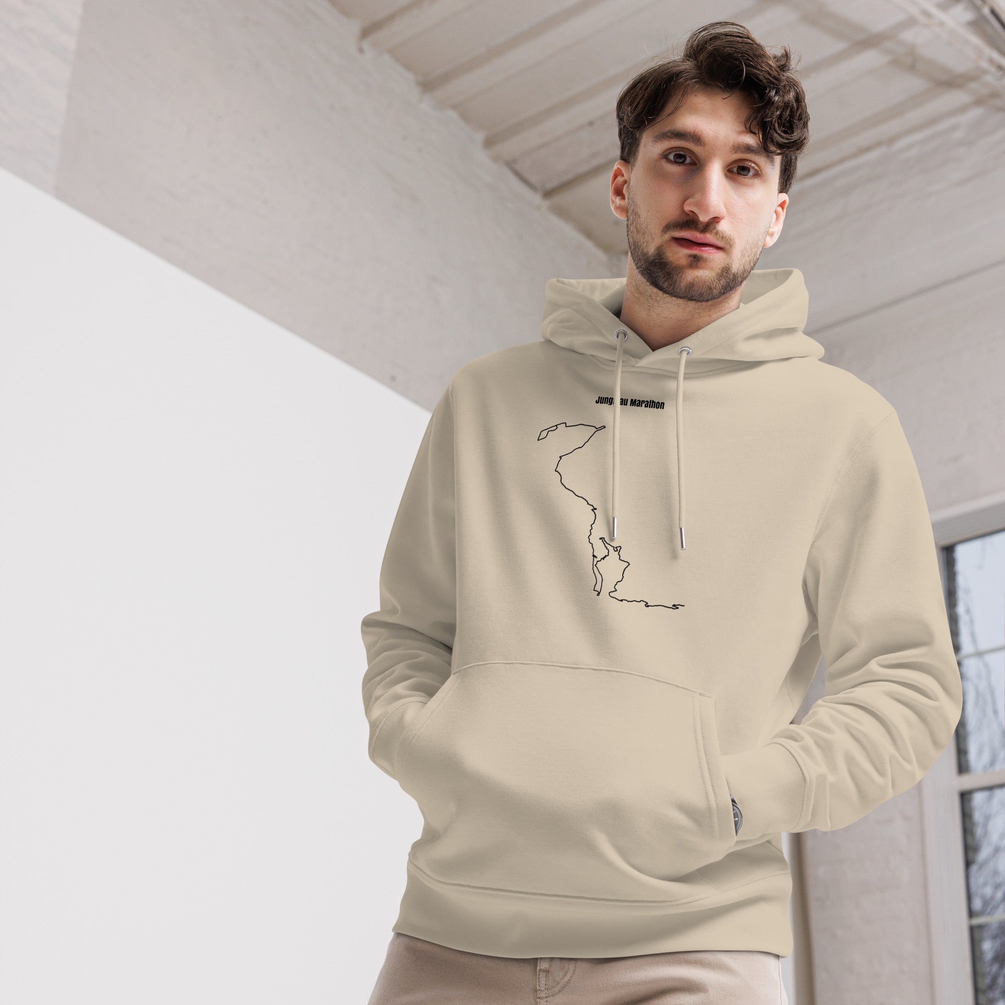 Man wearing a beige hoodie with a custom Strava route print art design indoors