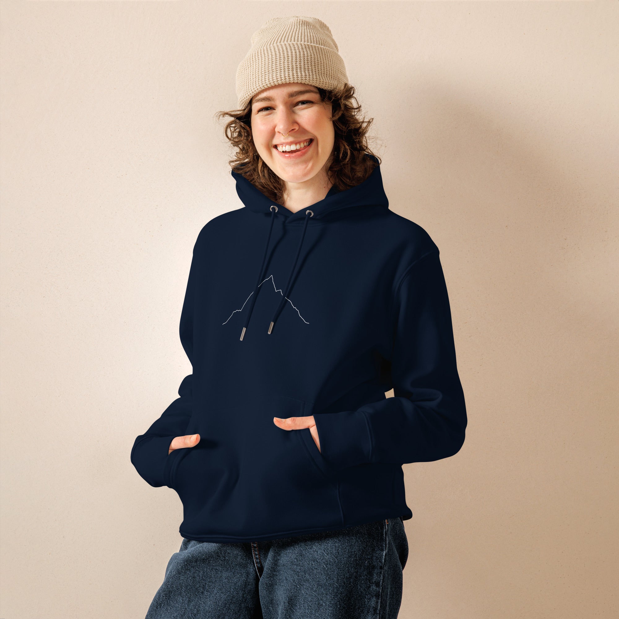 Person wearing a navy hoodie with custom Strava route print art and beige beanie against a beige background