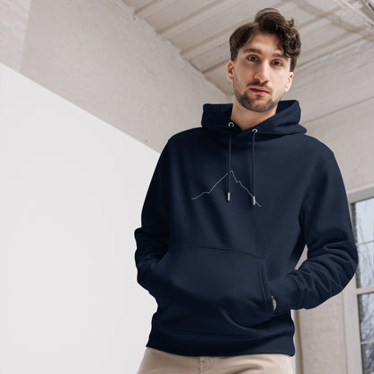 Man wearing a navy blue hoodie with custom Strava route print art indoors with a neutral background