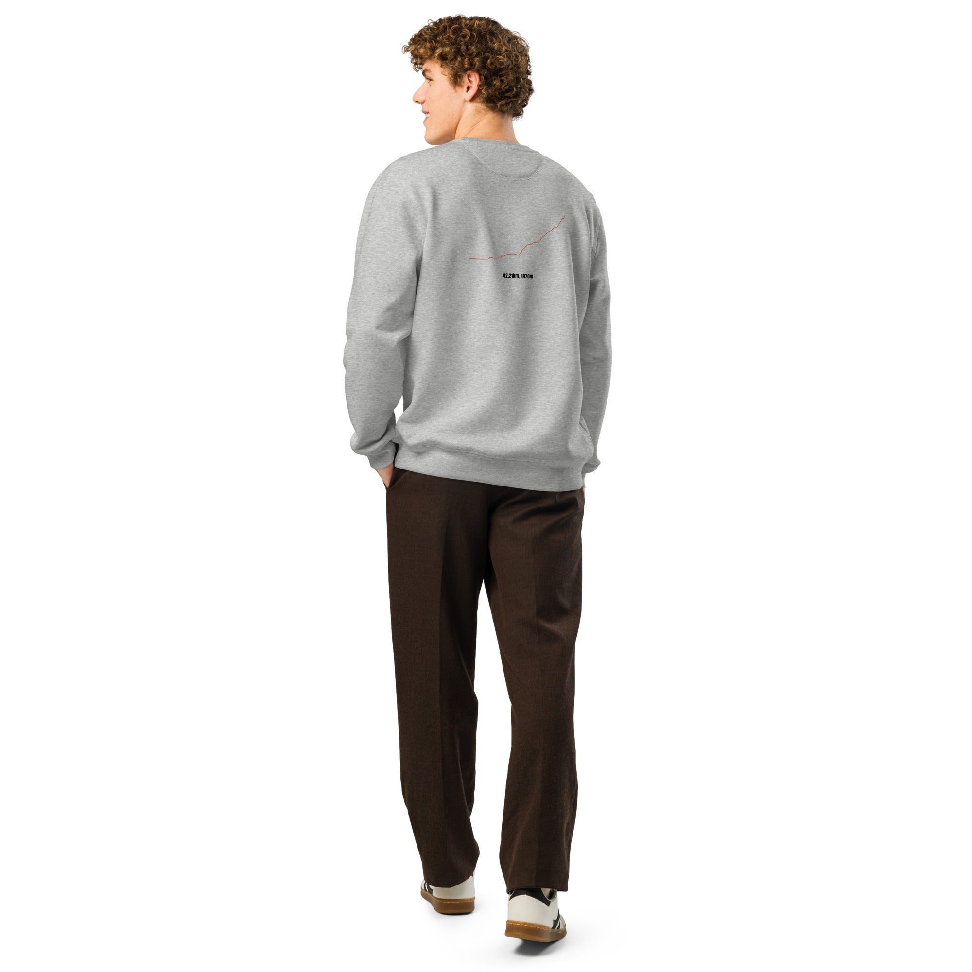 Person wearing a gray sweatshirt with custom Strava route print art and brown pants on a white background