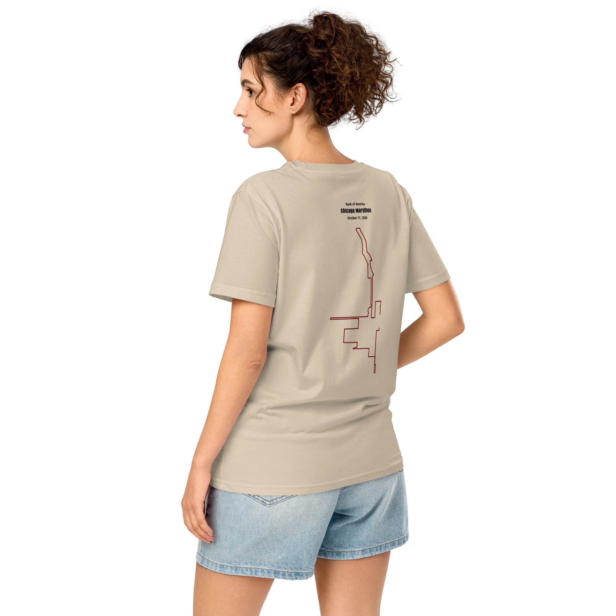 Woman wearing a beige t-shirt with a custom Strava route print art design on the back, standing against a white background