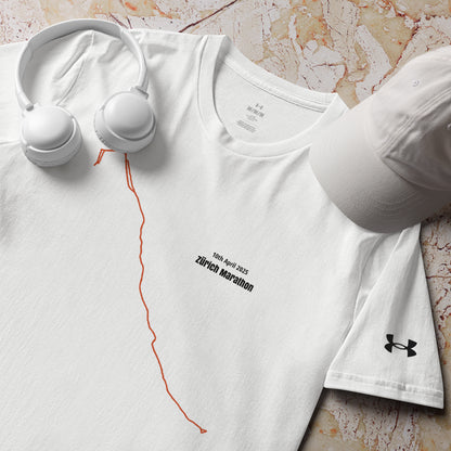 White t-shirt with marathon custom Strava route print design, cap, and headphones on a marble surface